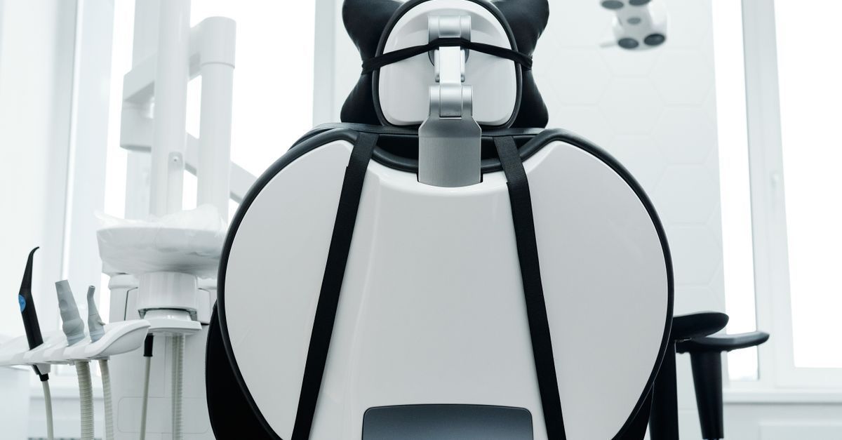 Modern dental chair in a bright clinic with white equipment and black armrests