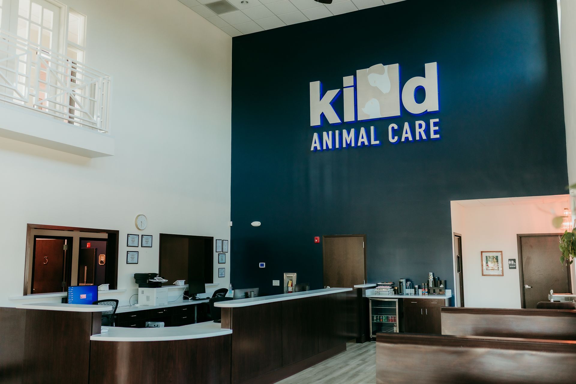 Reception area with dark blue wall logo reading “KID Animal Care” and a front desk counter