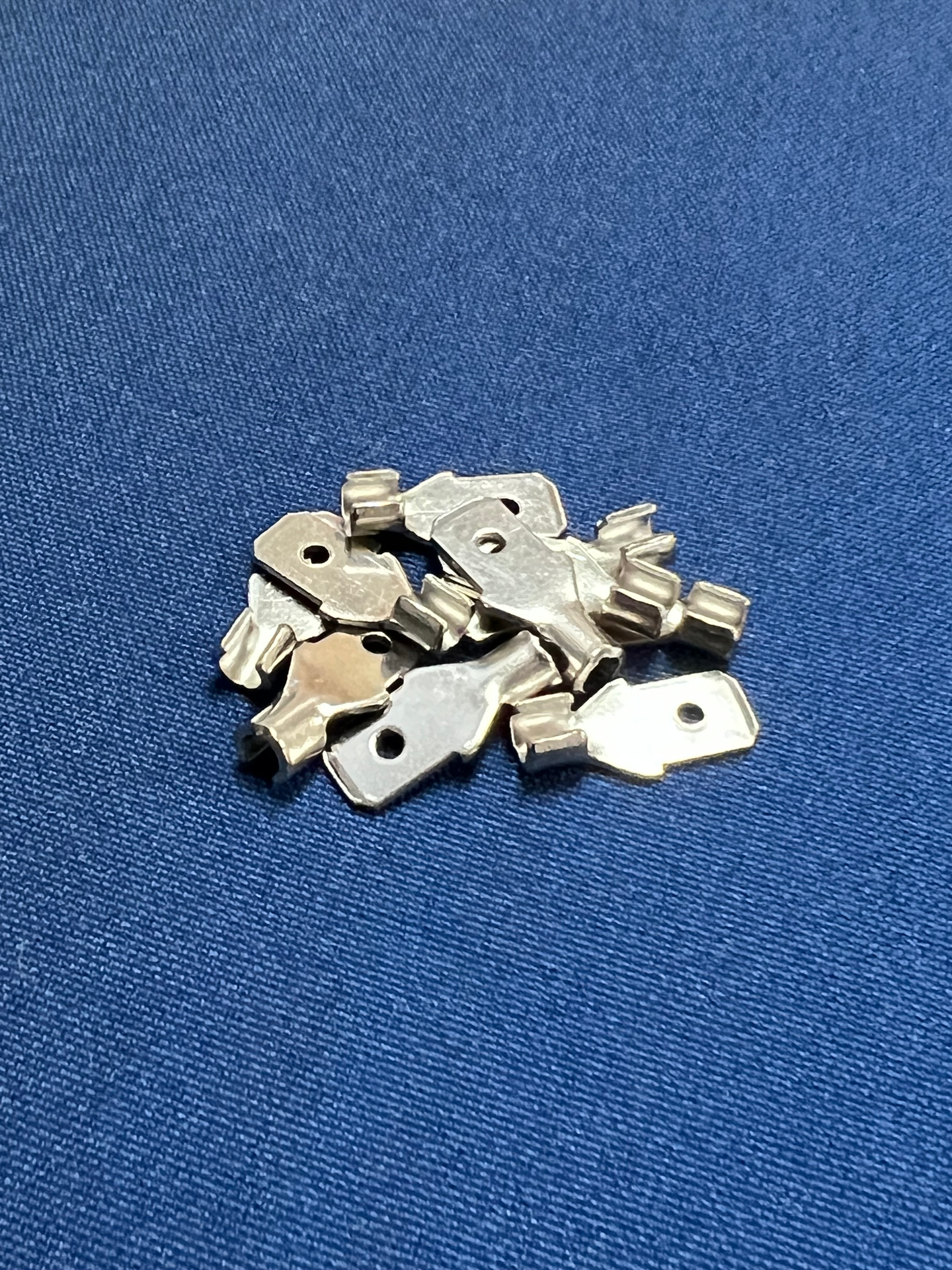A pile of keys sitting on top of a blue cloth.
