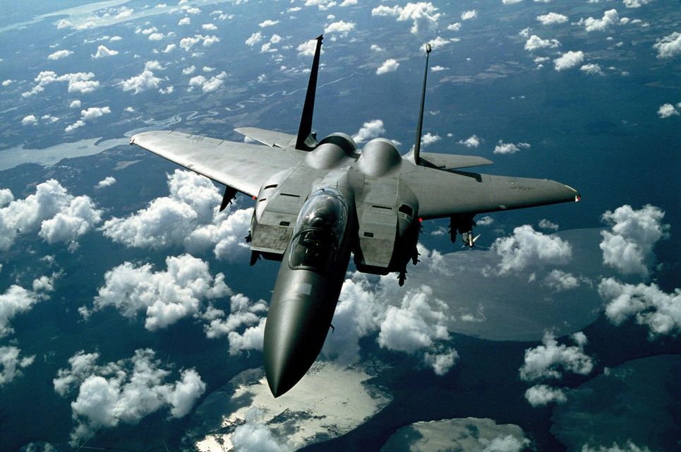 A fighter jet is flying through a cloudy sky