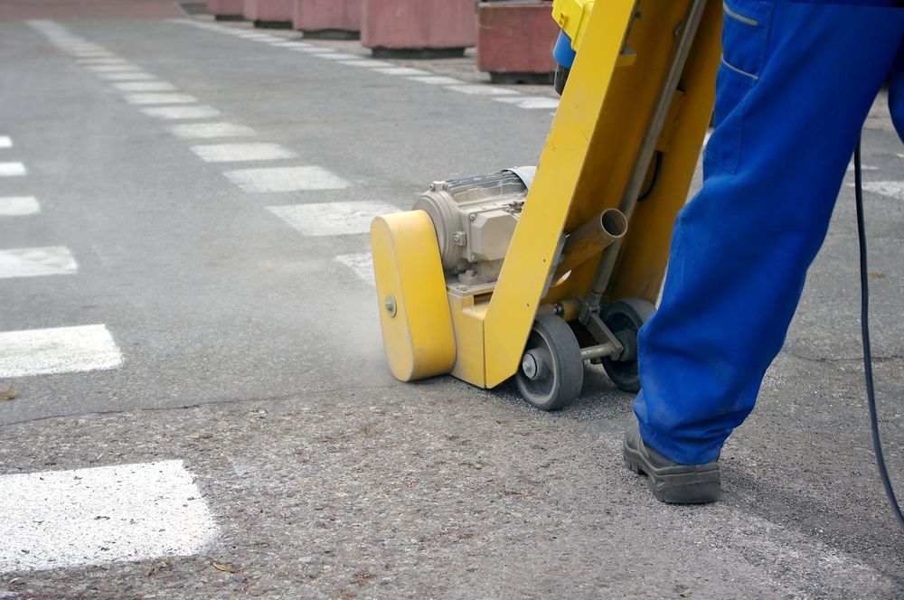 A Man is Using a Machine to Paint a Crosswalk on the Street — North Coast Line Marking in Talofa, NSW