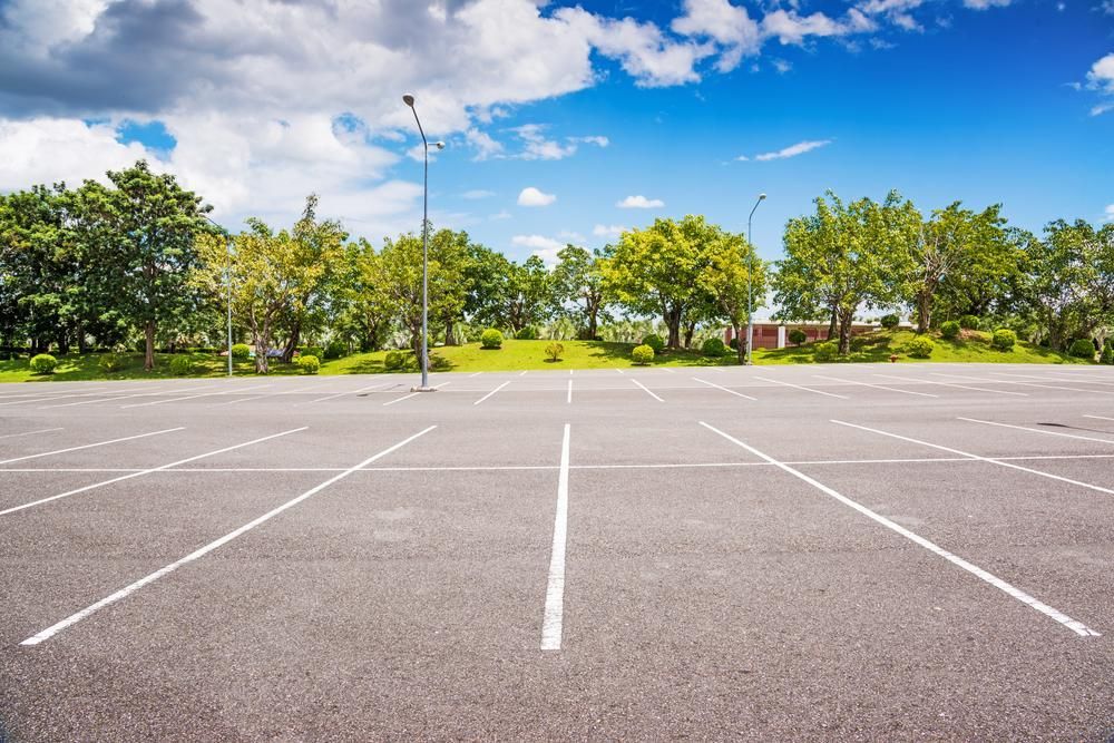 An Empty Parking Lot With Trees in the Background on a Sunny Day — North Coast Line Marking in Gold Coast, NSW