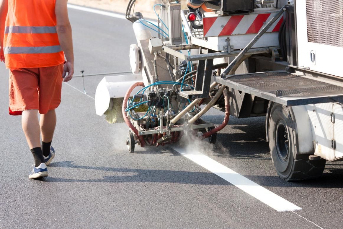 A Man is Walking Past a Machine That is Painting a Line on the Road — North Coast Line Marking in Grafton, NSW