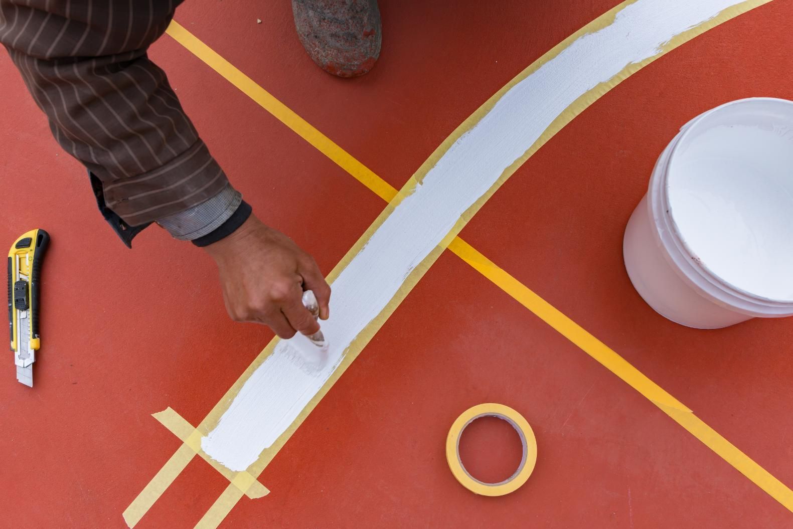 A Person is Painting a Line on a Basketball Court — North Coast Line Marking in Maclean, NSW