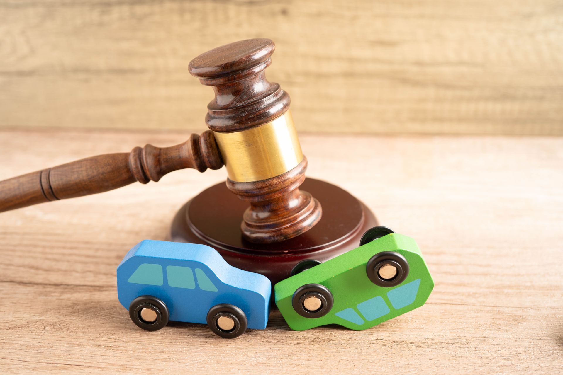 Car accident legal claim represented by a gavel and toy cars. Car accident legal claim represented by a gavel and toy cars.