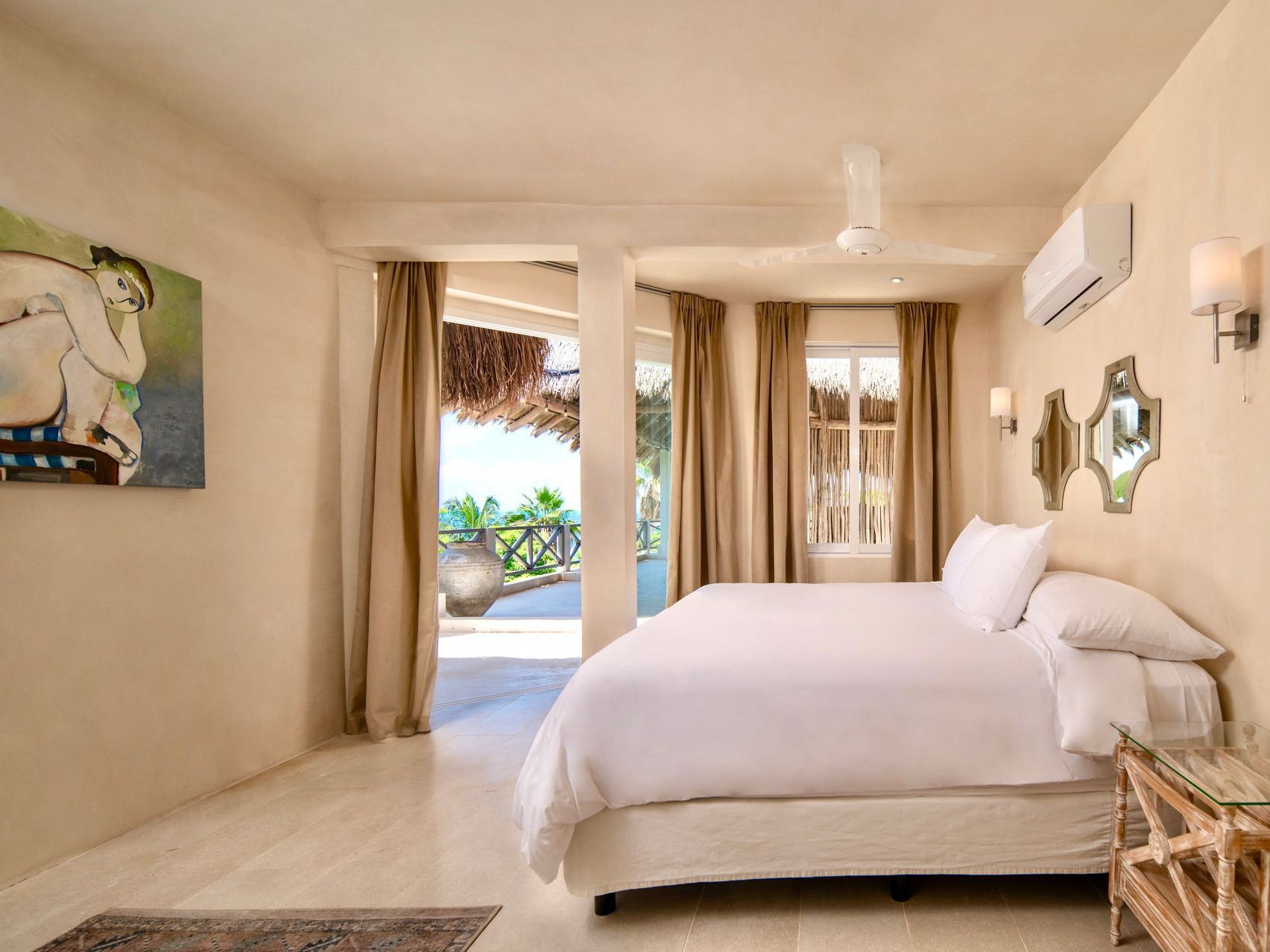 Bedroom with bed, art, balcony, and neutral tones.