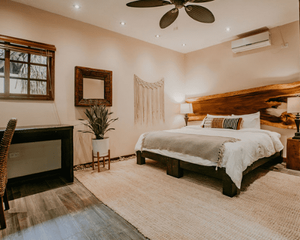 A bedroom with a large bed and a ceiling fan.
