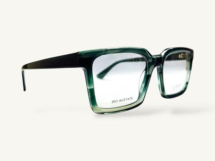 Occhiali rettangolari con lenti che sfumano dal verde al trasparente e aste nere su sfondo bianco.