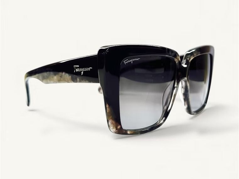 Occhiali da sole neri oversize con lenti sfumate su sfondo bianco