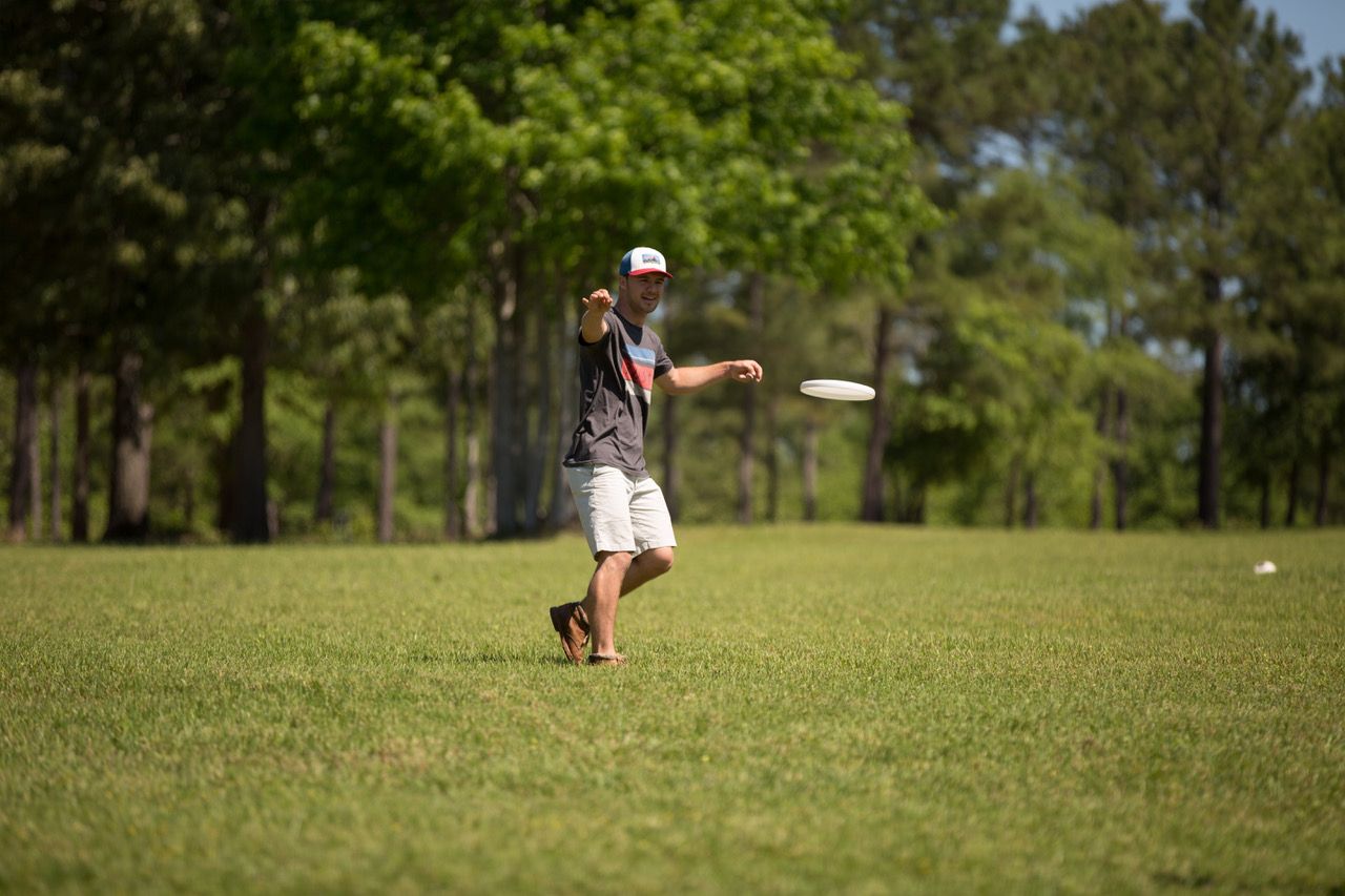 A man is throwing a frisbee in a field.