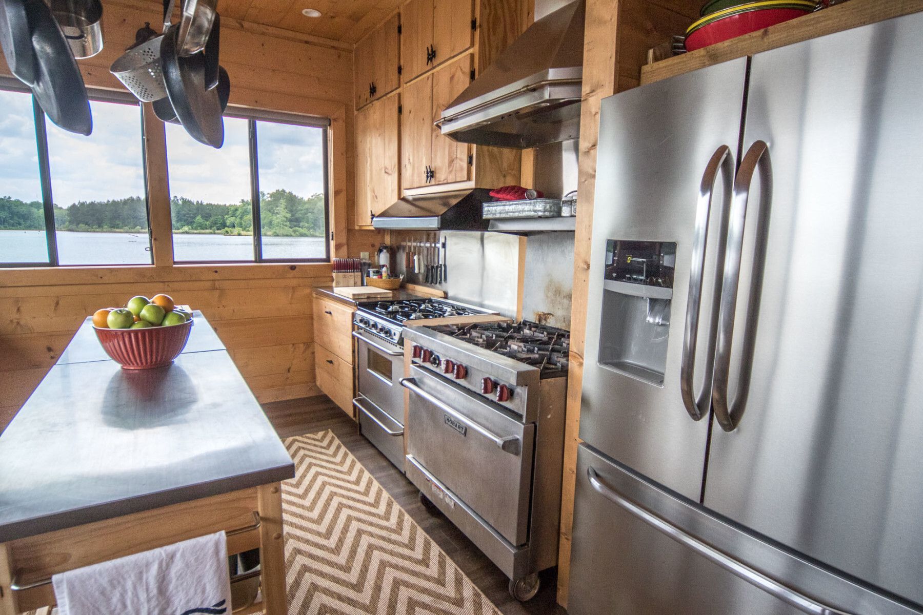 A kitchen with stainless steel appliances , a stove and a refrigerator.