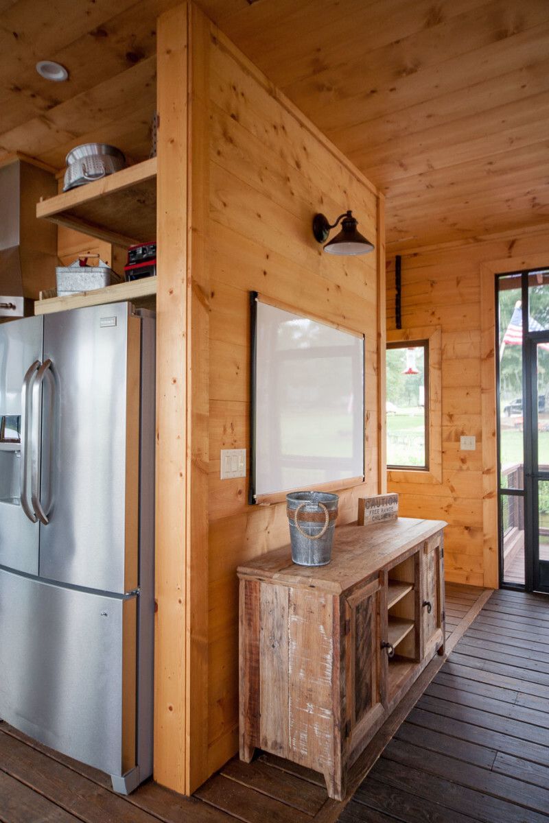 A kitchen with a stainless steel refrigerator and a wooden cabinet