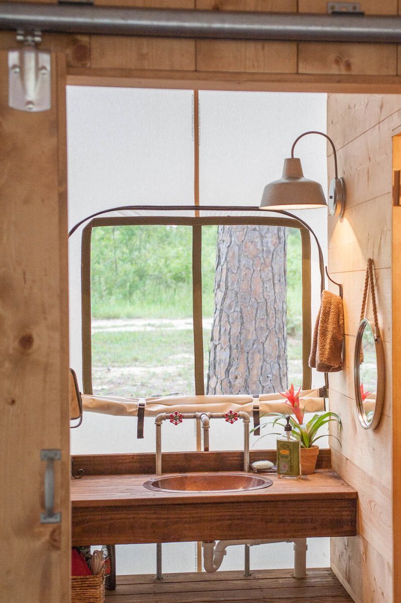 A bathroom with a sink and a window with a tree in the background