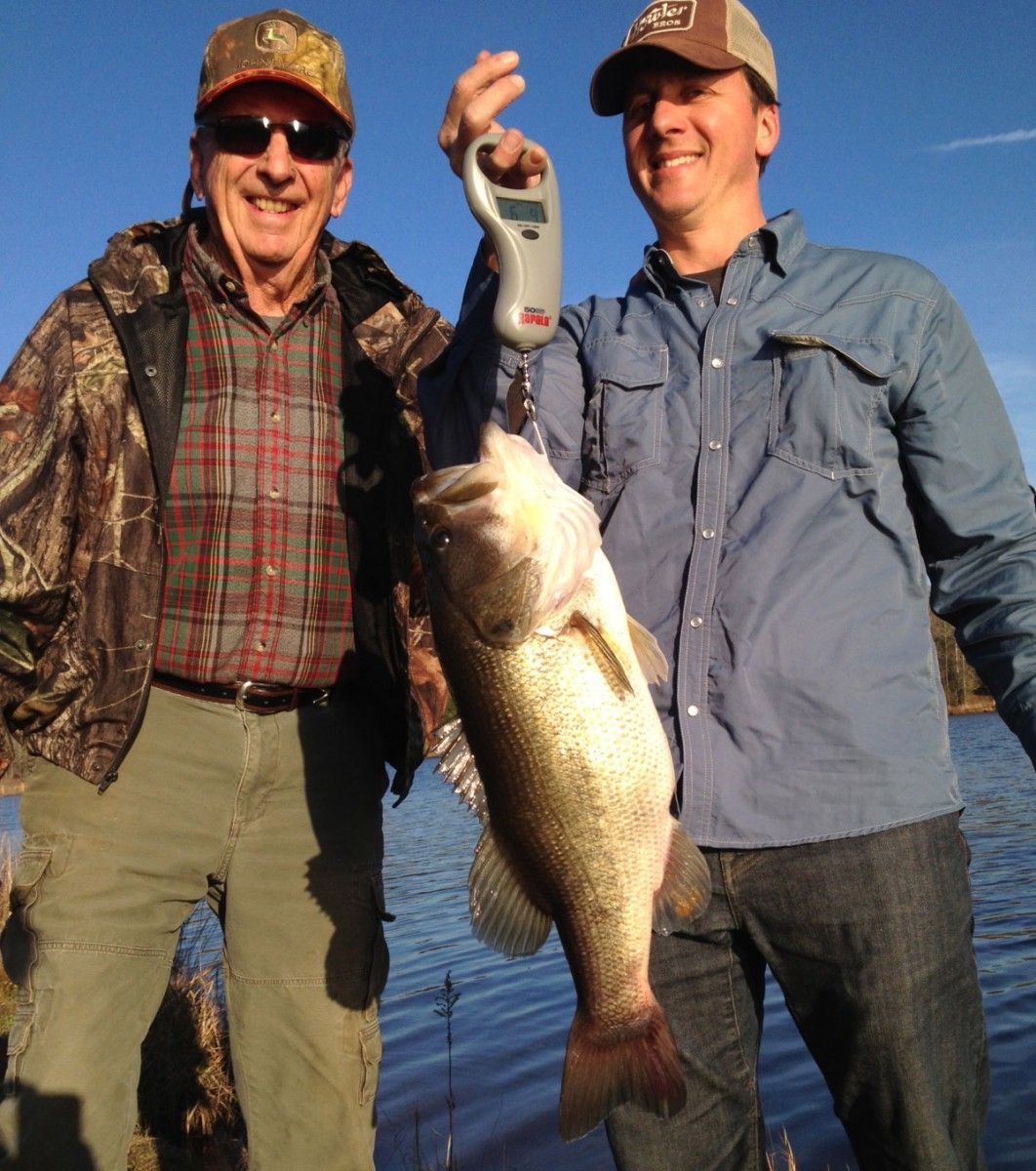 Two men standing next to each other holding a large fish