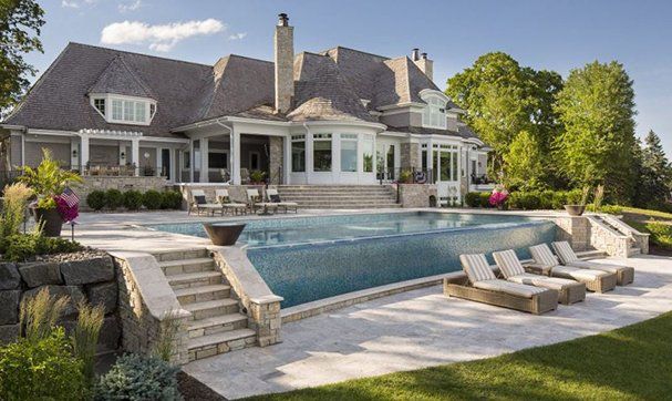 A large house with a large swimming pool in front of it.