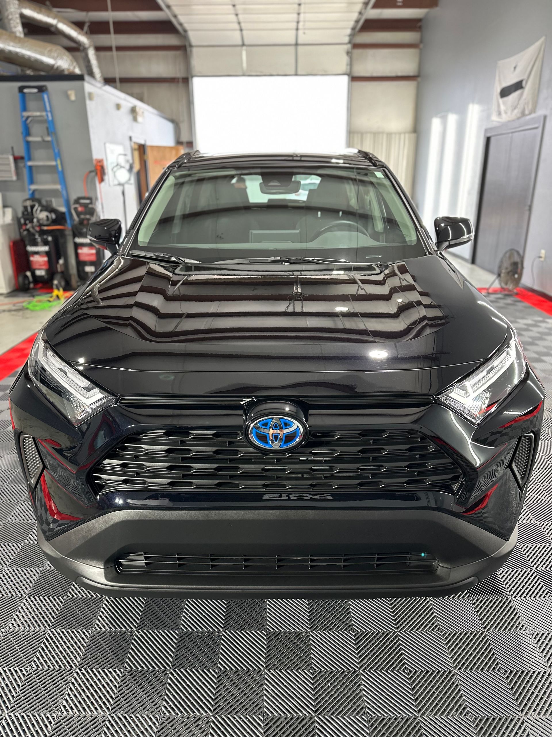 A black toyota rav4 is parked in a garage.