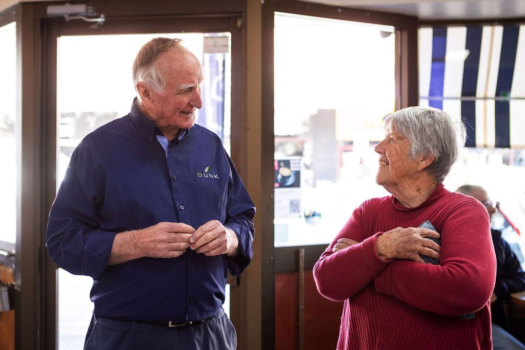 A man and a woman are talking to each other in a restaurant.