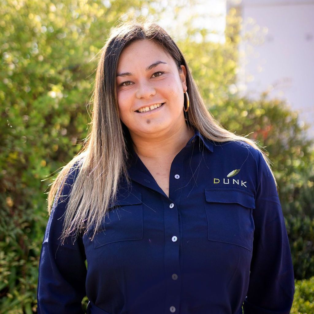 A woman in a blue shirt is smiling for the camera.