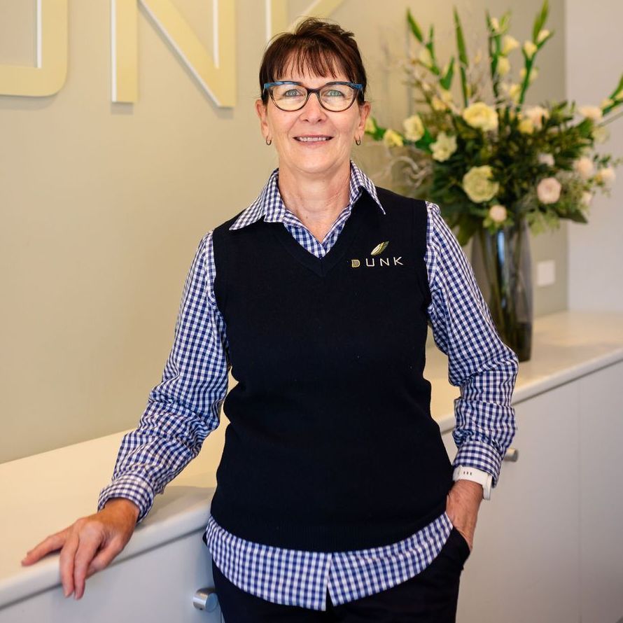 A woman wearing glasses and a black vest with the word link on it