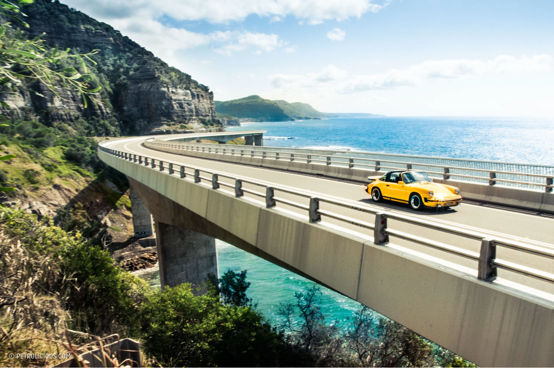 A red sports car on a scenic drive tour route near Sydney