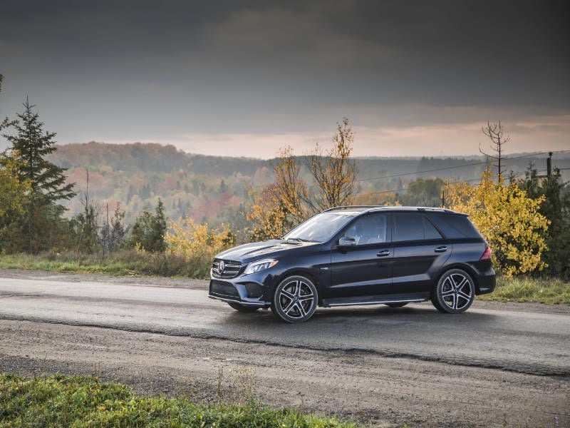 A family enjoying a scenic road trip in an SUV with kids and luggage