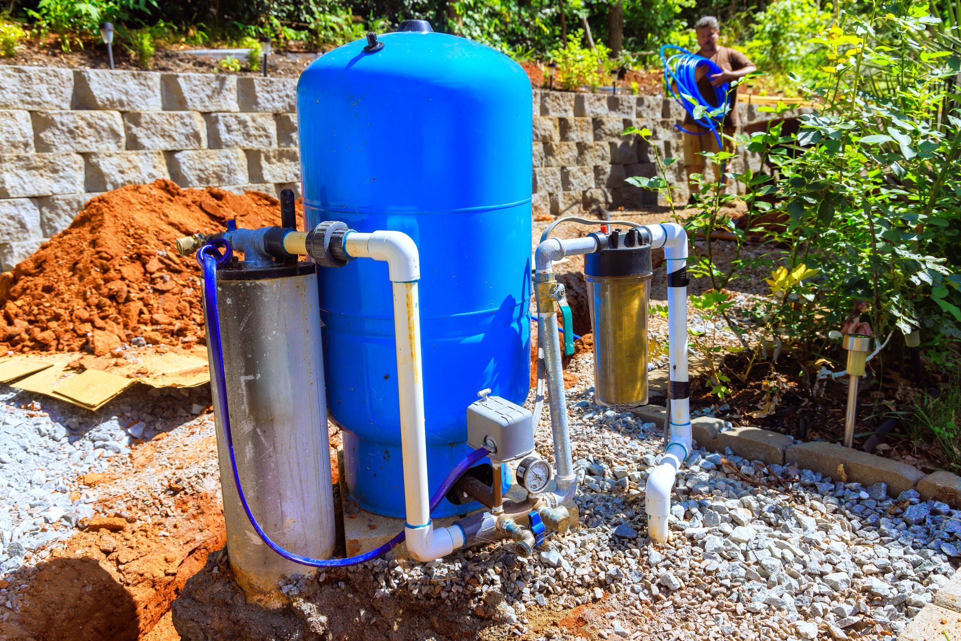 Water filtration and storage tanks with pump equipment in a rural outdoor setting