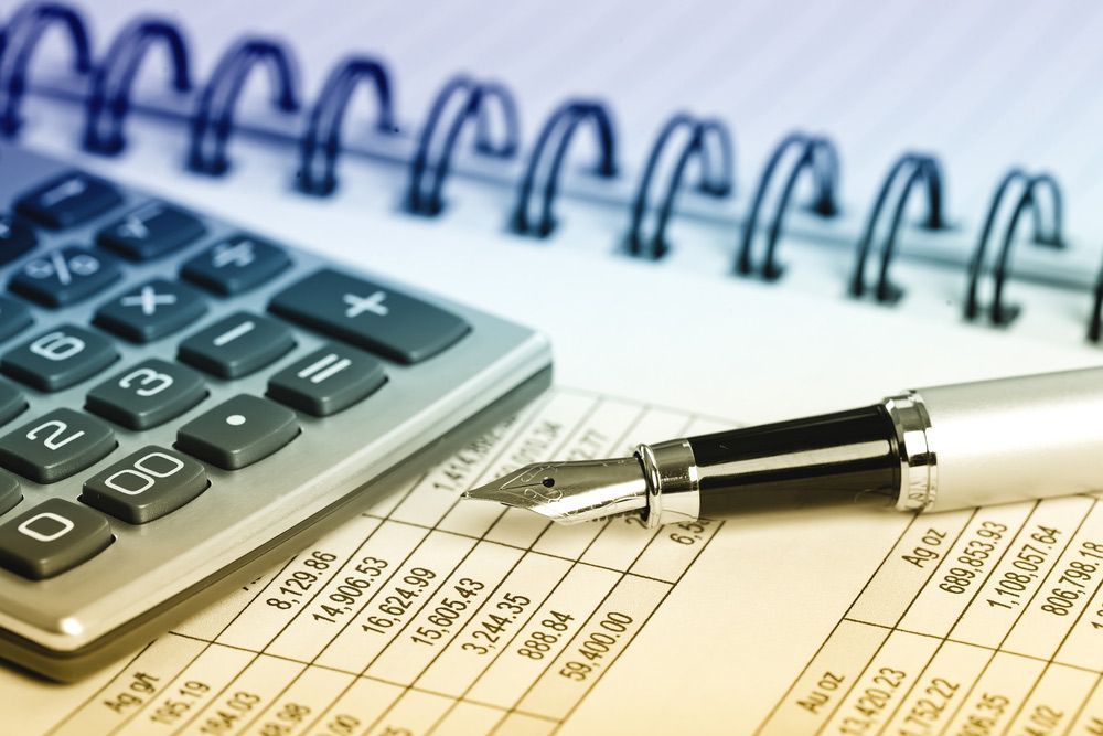 A Pen is on Top of a Spiral Bound Notebook Next to a Calculator — D&T Accounting & Bookkeeping In Umina Beach, NSW