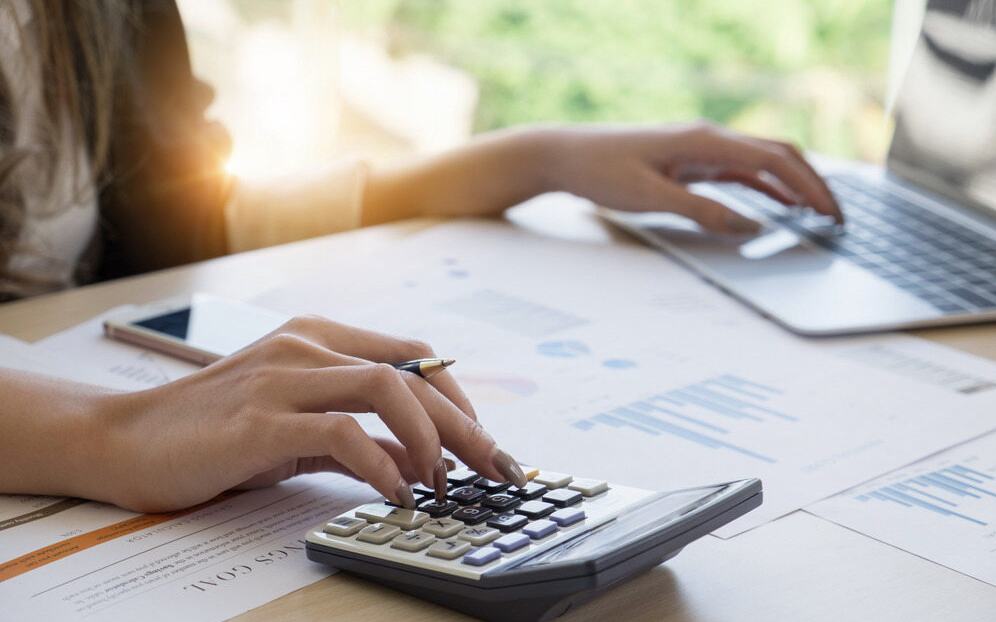 A Woman is Using a Calculator — D&T Accounting & Bookmaking Services in Woy Woy, NSW