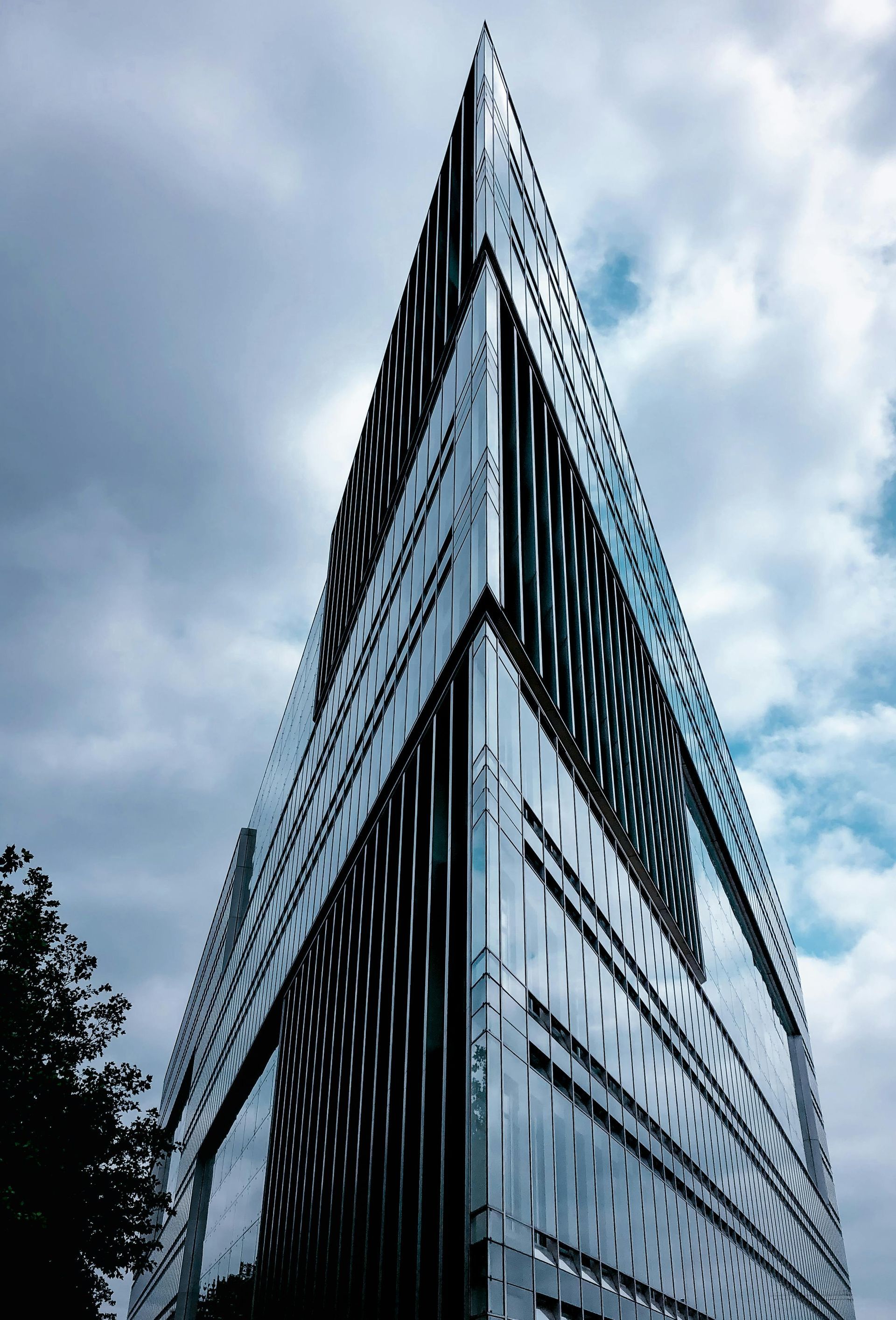 Looking up at a tall building with a cloudy sky in the background