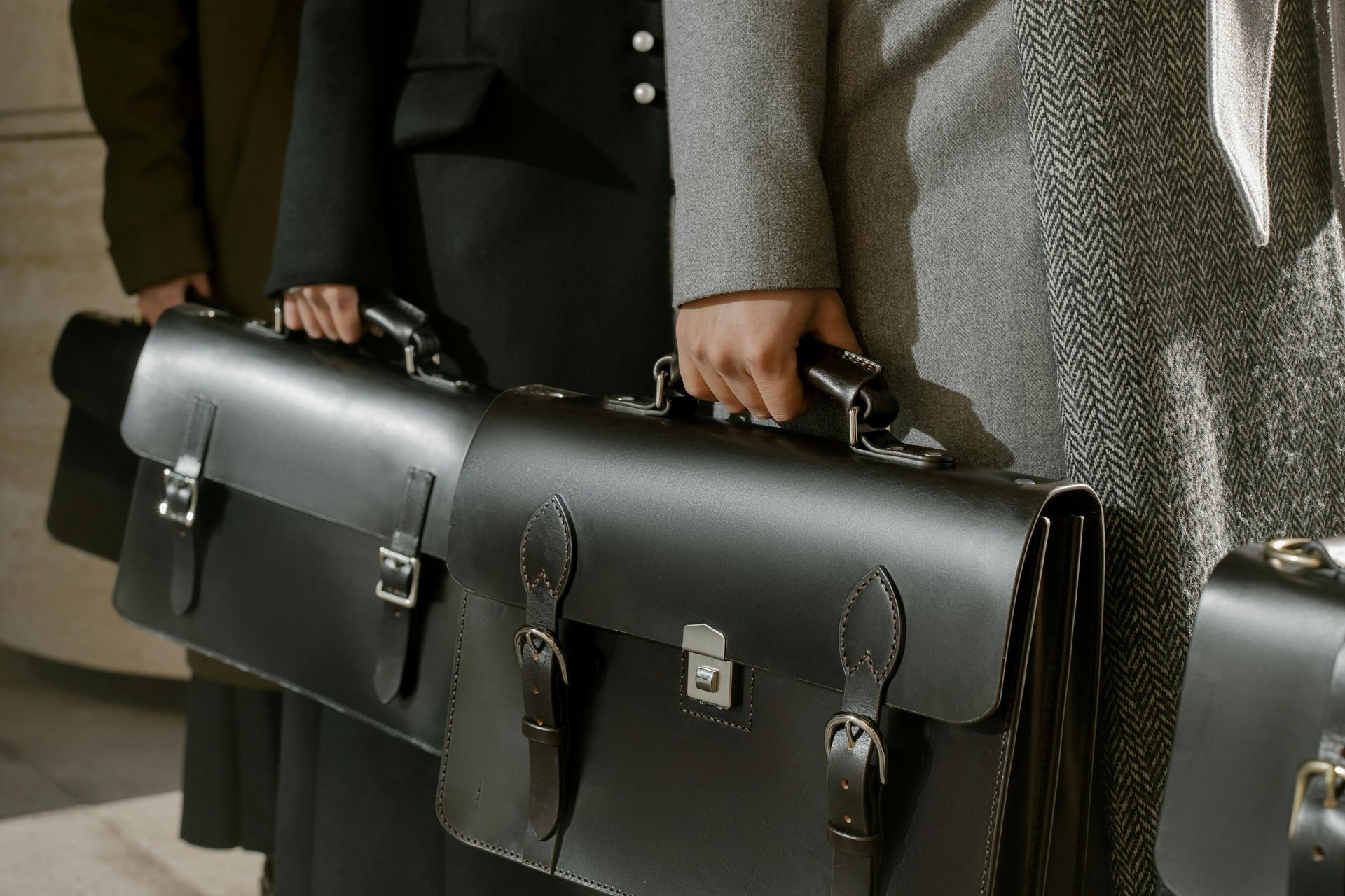 A man is standing in front of a glass wall holding a clipboard.