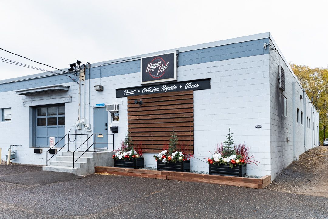 Exterior view of a light gray brick building with a black sign