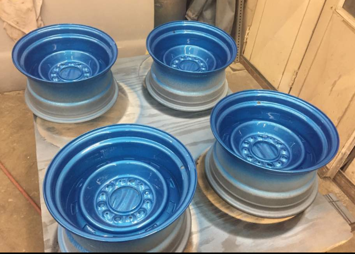 Four blue rims are sitting on top of each other on a table