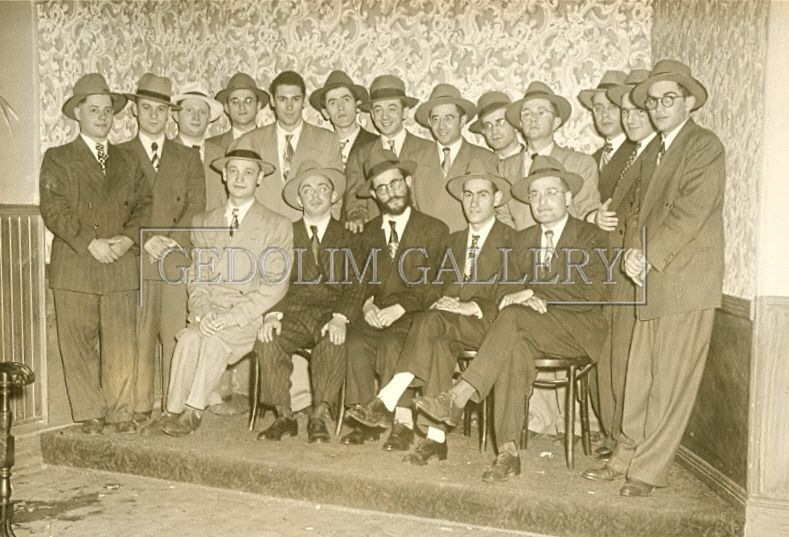 A group of men in suits and hats are posing for a picture.
