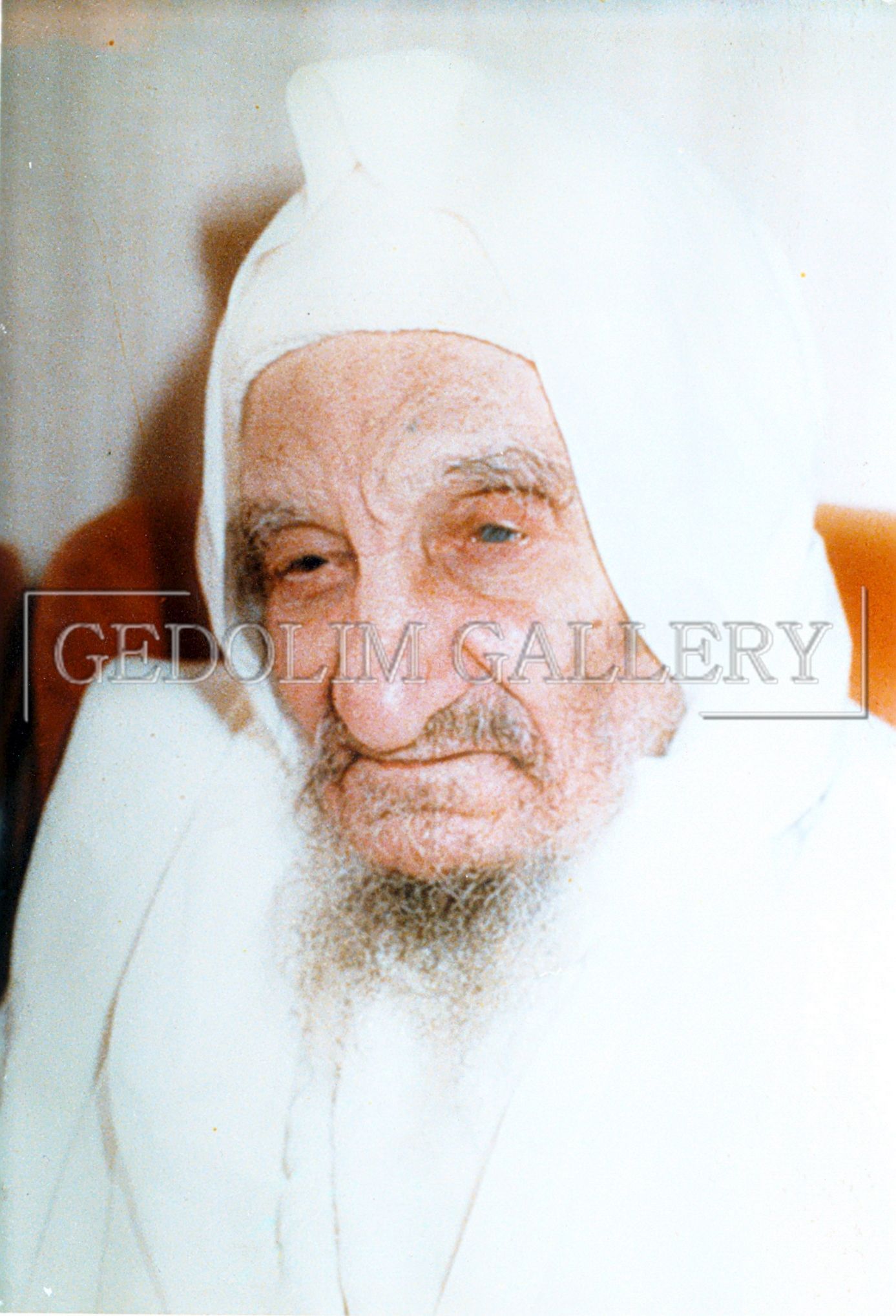 An old man with a beard wearing a white robe