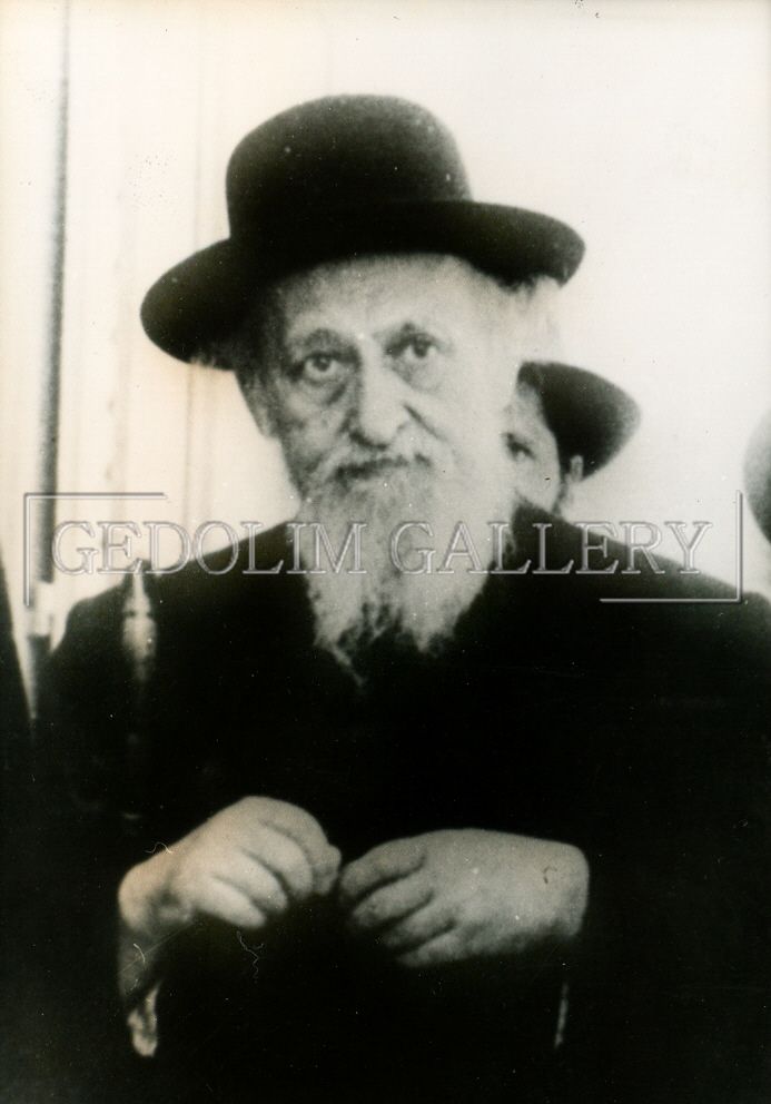 A black and white photo of a man with a beard wearing a hat