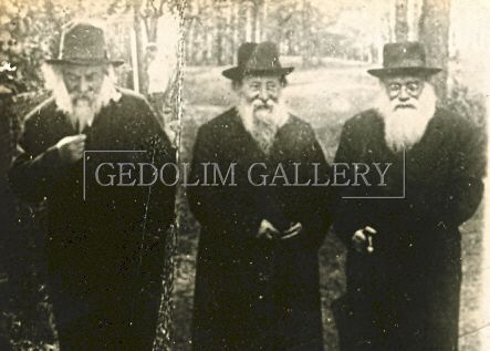 Three men with beard and hats are standing next to each other in a black and white photo.