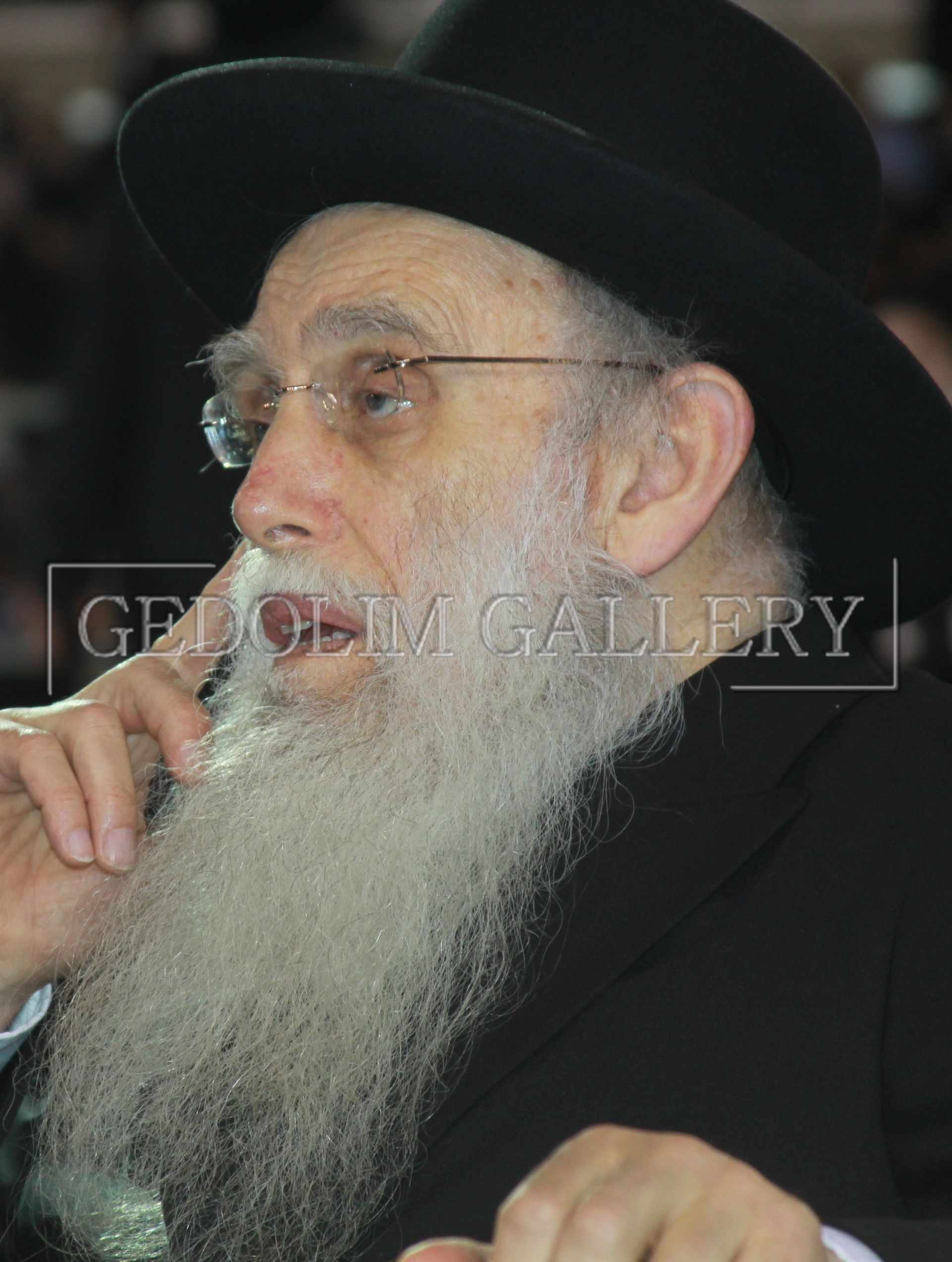 A man with a beard wearing glasses and a hat with the word gallery on the bottom