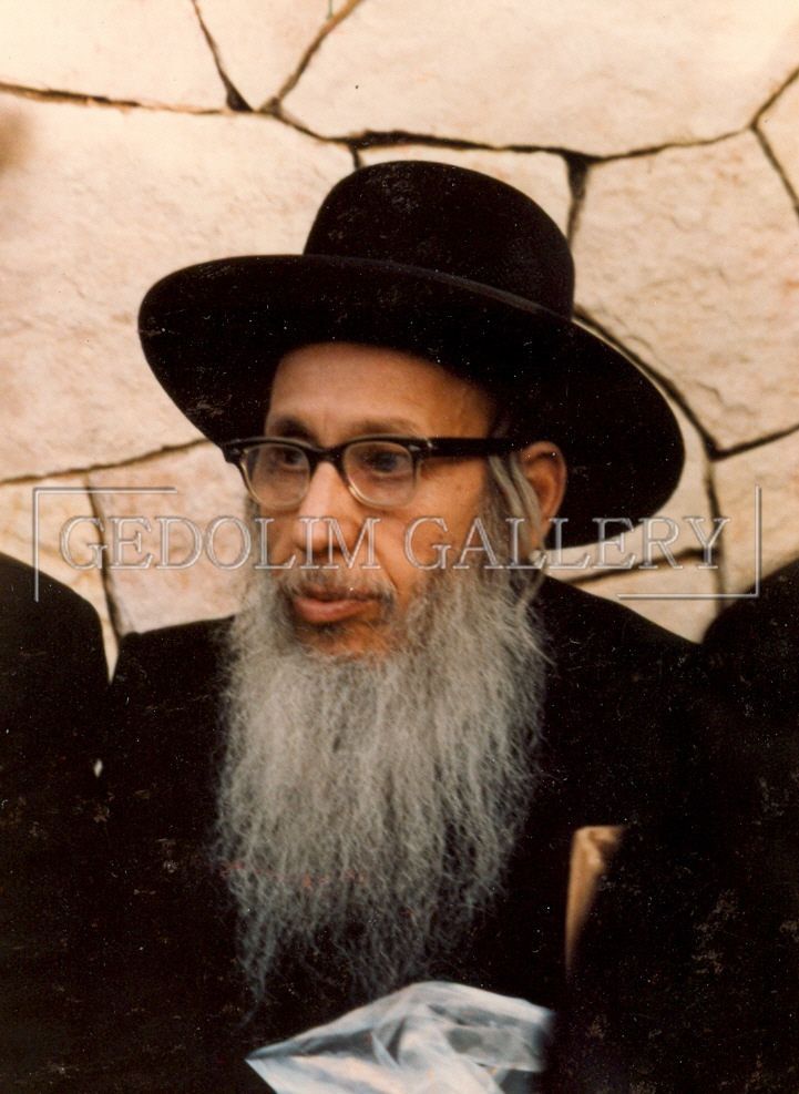 A man with a beard wearing a black hat and glasses