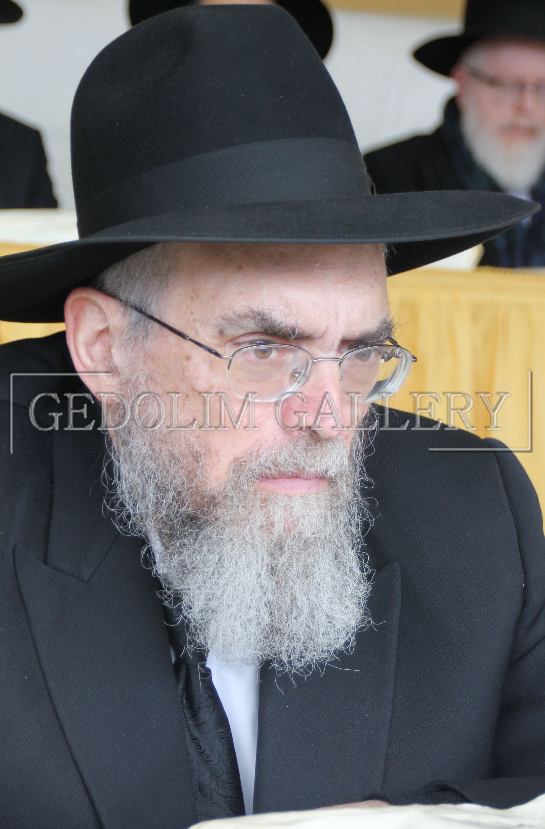 A man with a beard wearing a black hat and glasses