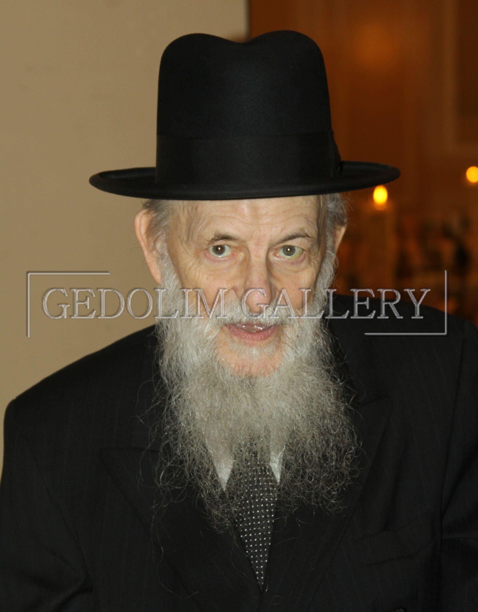 A man with a beard is wearing a black hat