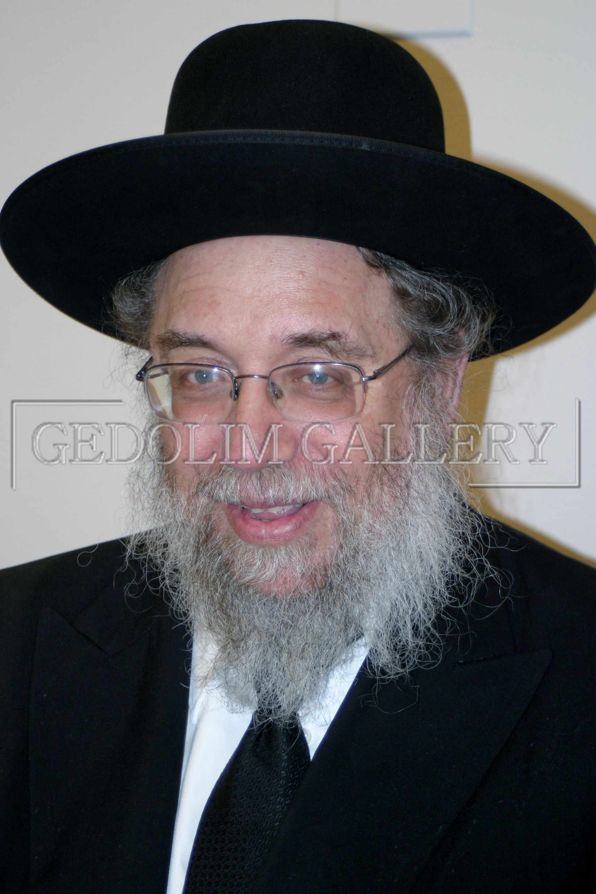 A man with a beard wearing a black hat and glasses