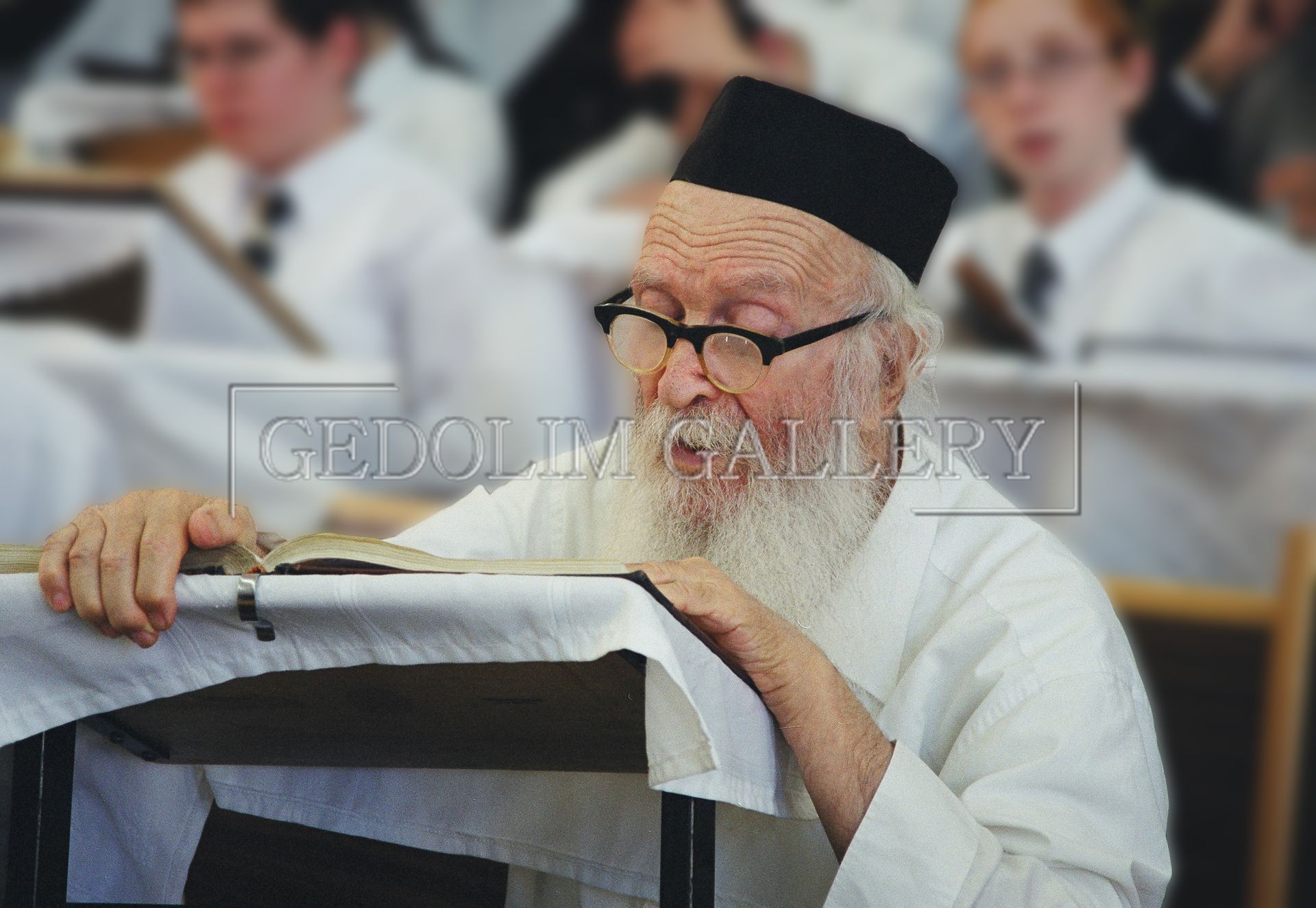 A man with glasses and a black hat is reading a book