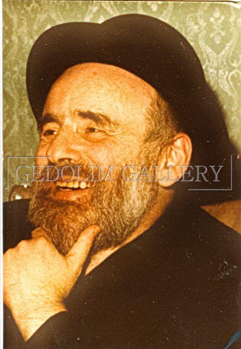 A man with a beard is wearing a black hat and smiling