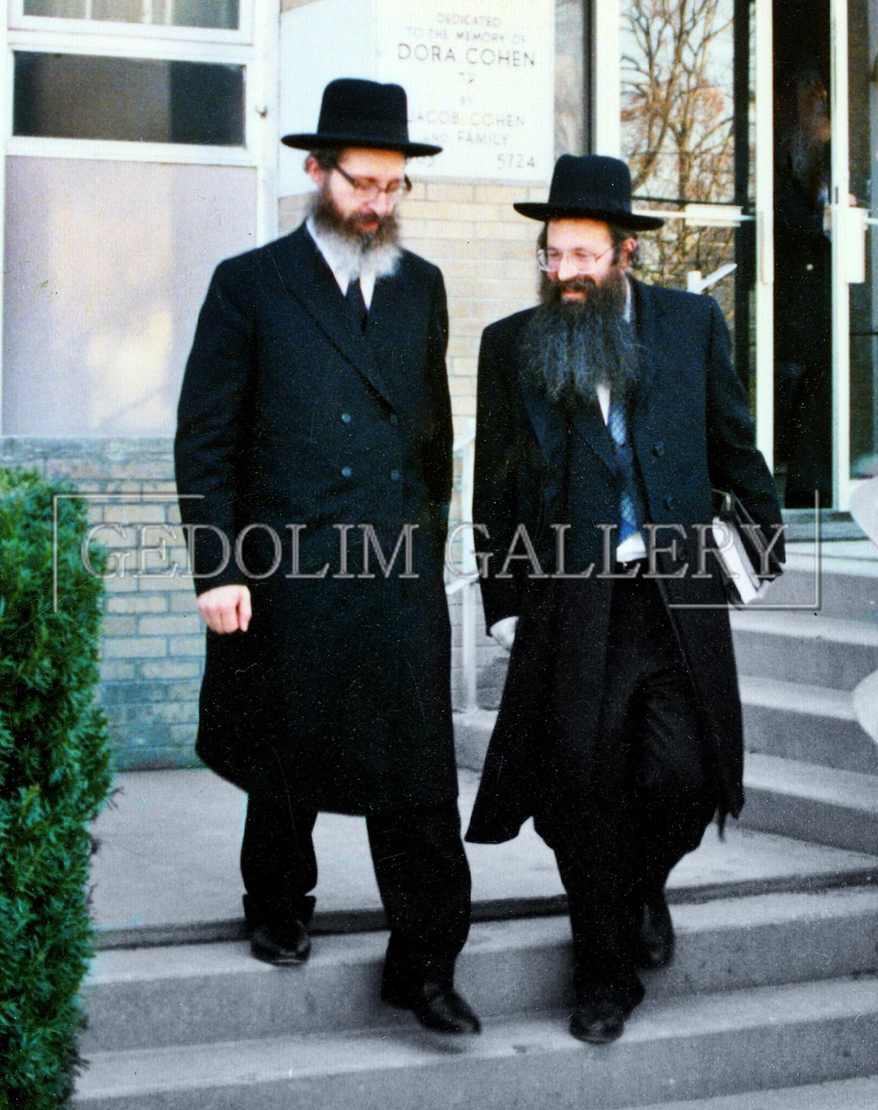 Two men are walking in front of a building that says dolim gallery