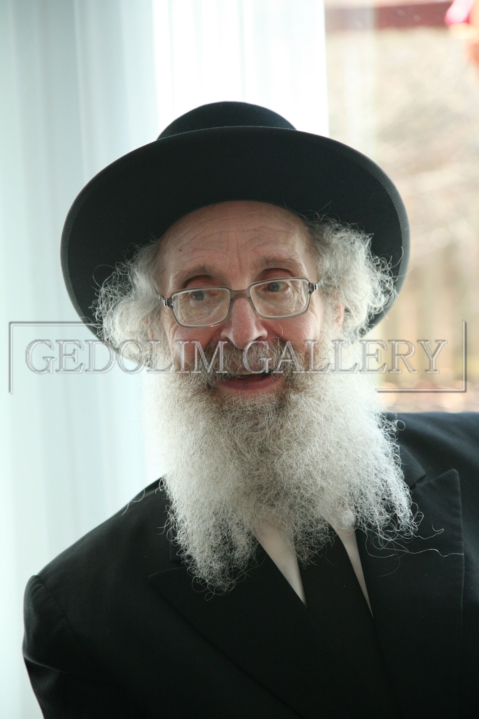 A man with a beard wearing a hat and glasses
