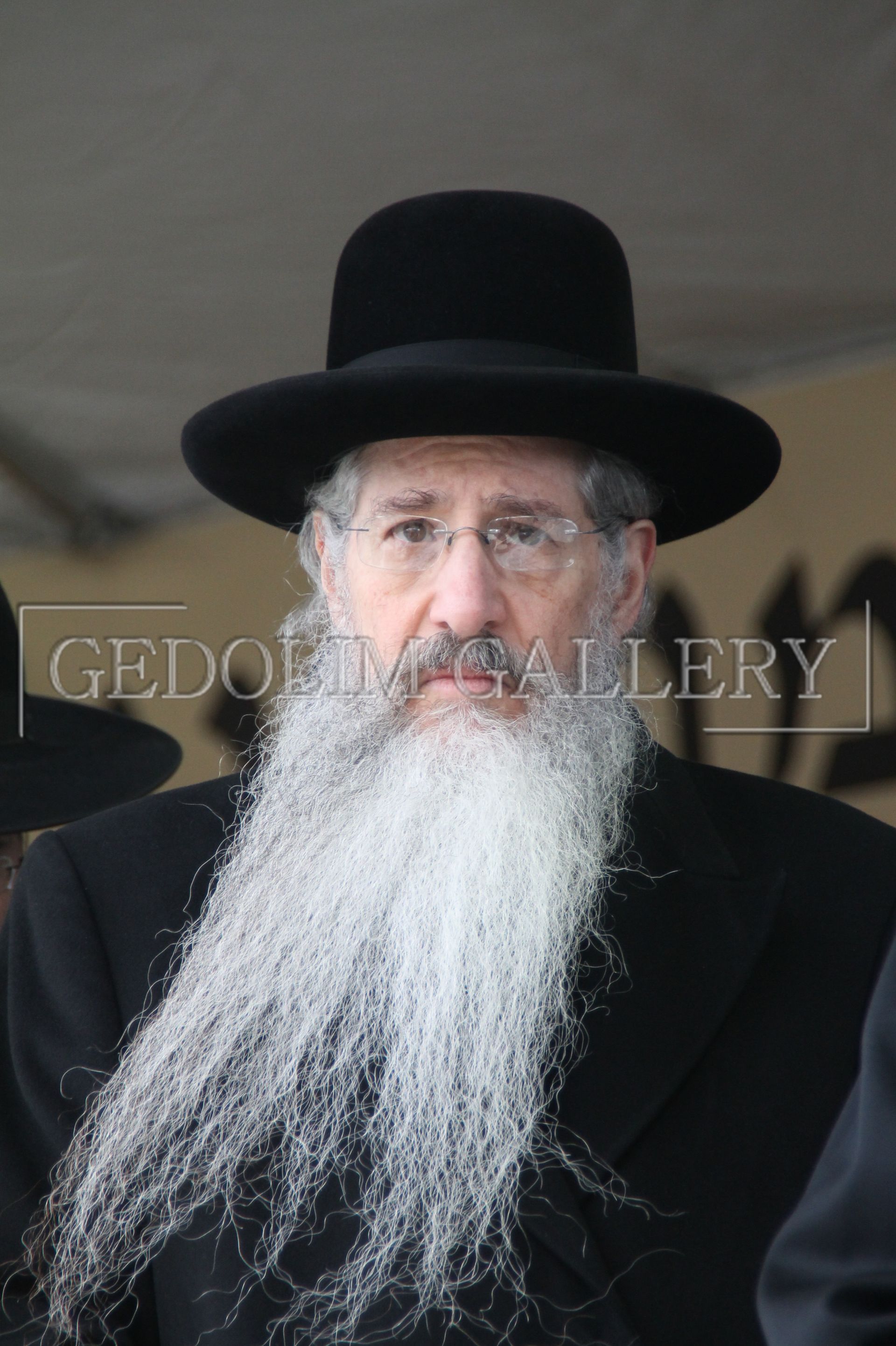 A man with a beard wearing a black hat and glasses