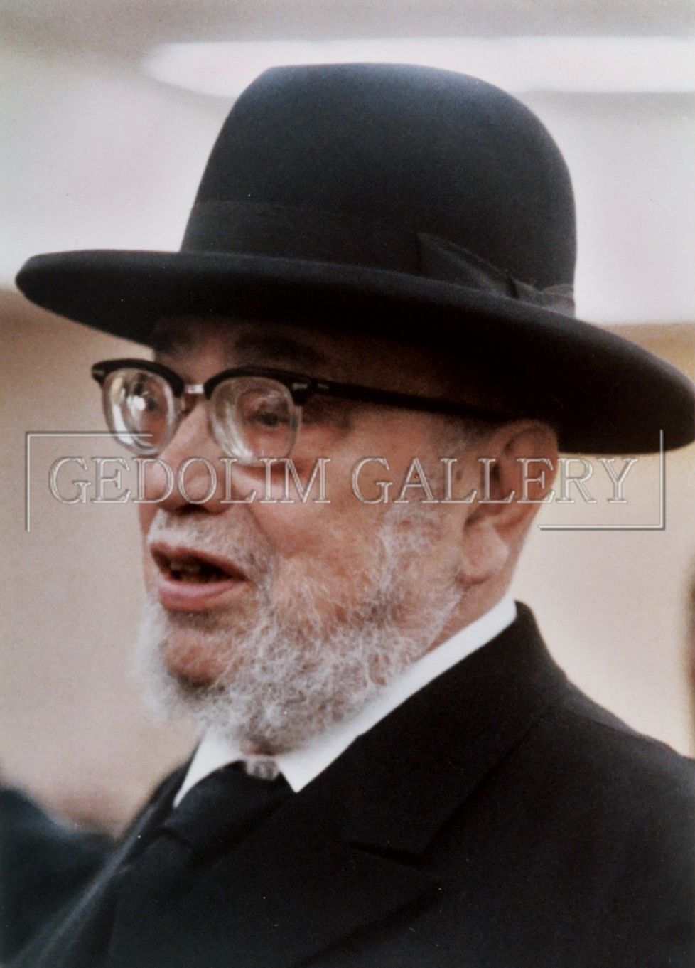 A man with a beard wearing a black hat and glasses