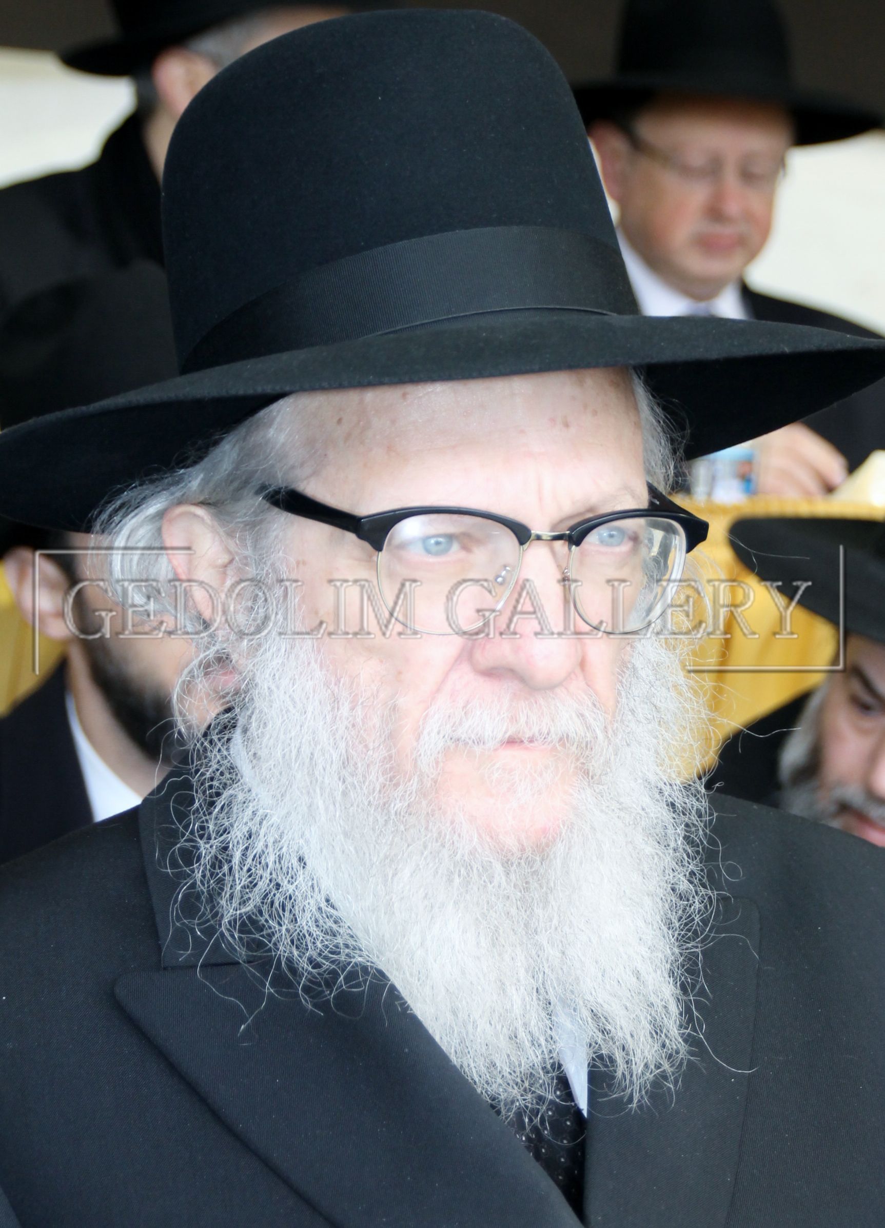 A man with a beard wearing a black hat and glasses