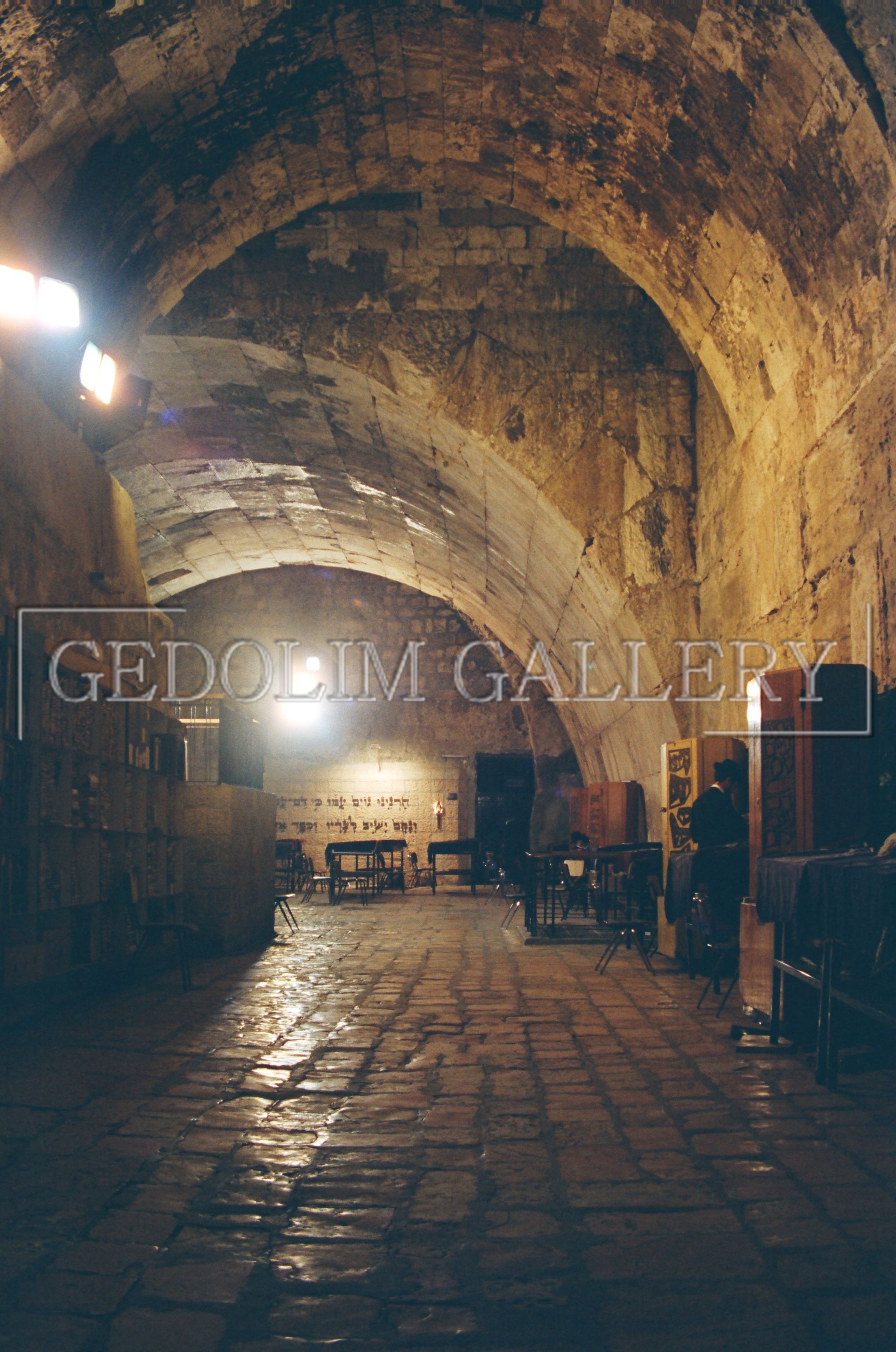 A dark tunnel with a light shining through the ceiling.