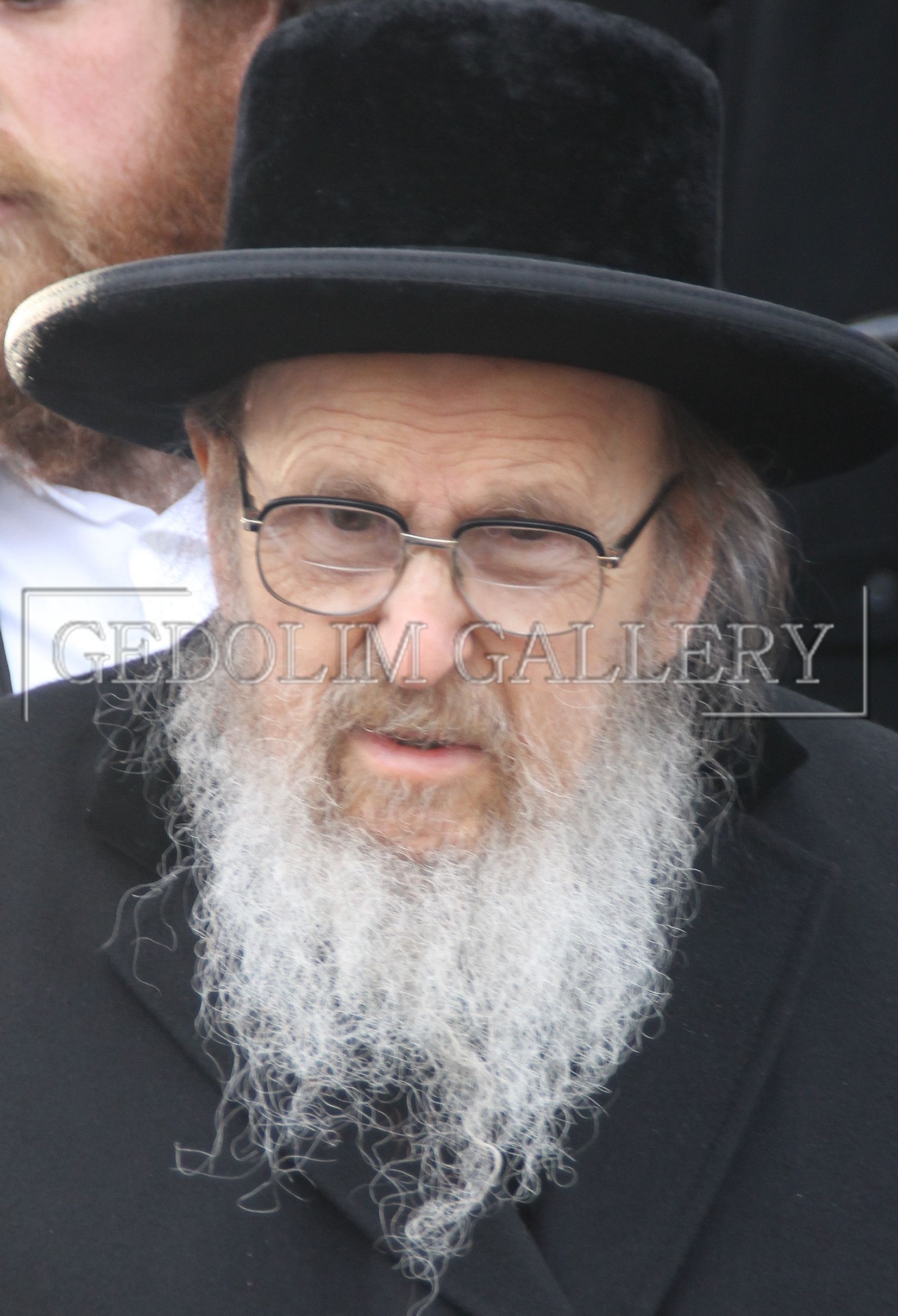 A man with a beard wearing a hat and glasses